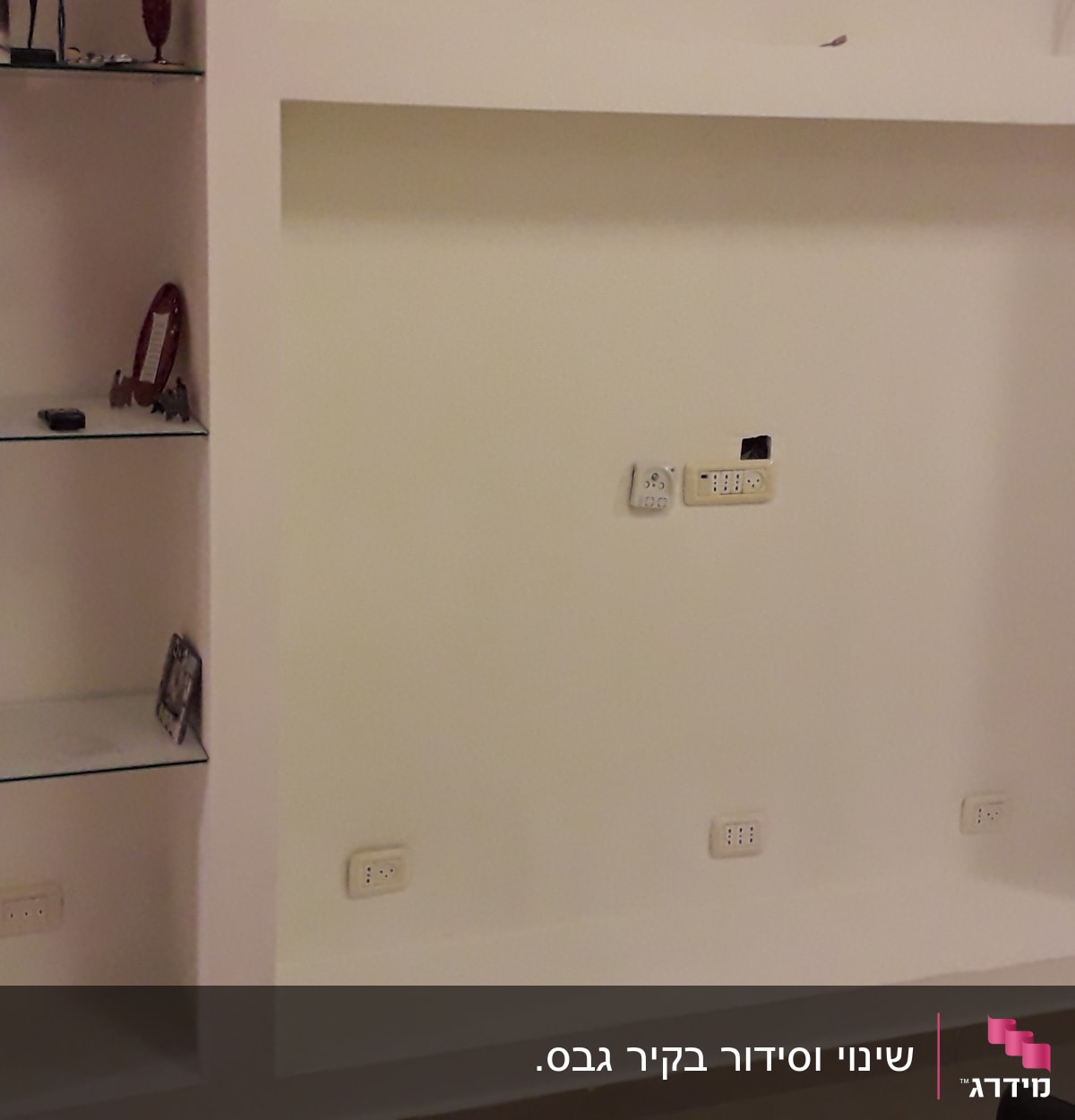 קיר גבס עם מדפים ושקעים חשמליים